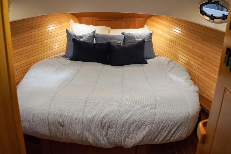 Slide: The Image of Luxurious 2024 True North 34 yacht cabin with cozy bedding and elegant wood paneling. - 10
