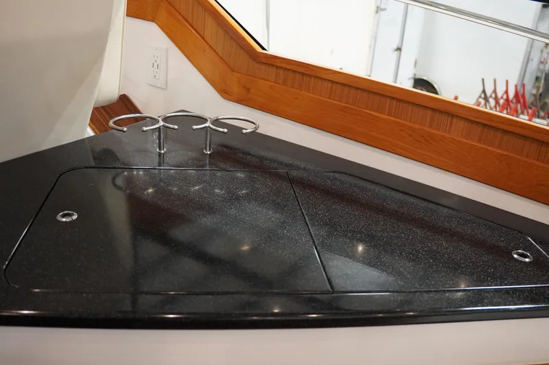 Slide: The Image of 2024 True North 34 yacht interior with sleek black countertop and wooden trim. - 11