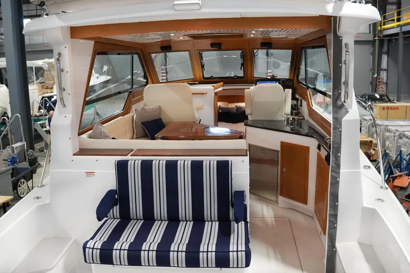 Slide: The Image of 2024 True North 34 boat interior with striped seating, wooden accents, and modern amenities. - 25