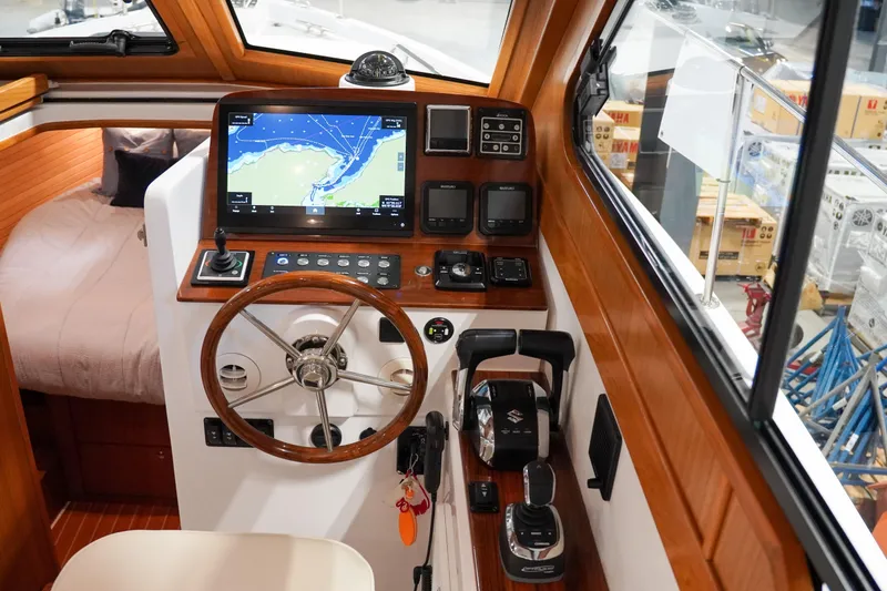 Slide: The Image of 2024 True North 34 boat cockpit with navigation system and wooden steering wheel. - 26