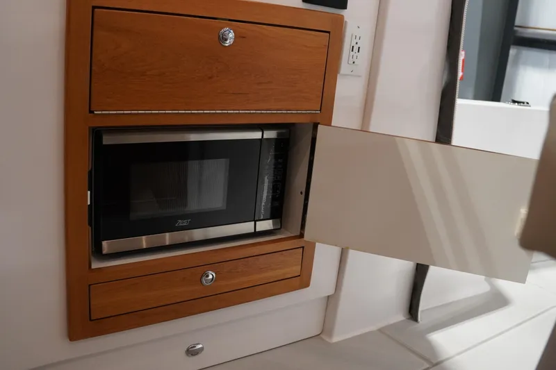 Slide: The Image of 2024 True North 34 yacht interior with built-in microwave and wooden cabinetry. - 8