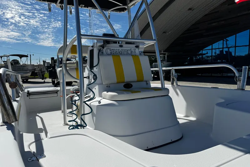 Slide: The Image of 2006 Champion 24 Bay Champ boat interior with yellow and white seating under a clear sky. - 11