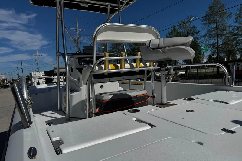 Slide: The Image of 2006 Champion 24 Bay Champ boat interior with seating and console, parked outdoors. - 14