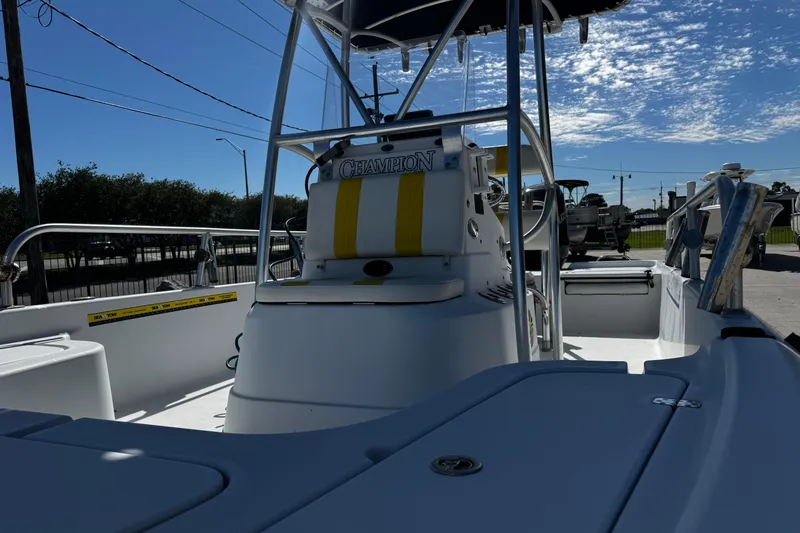 Slide: The Image of 2006 Champion 24 Bay Champ boat interior with console and seating under clear blue sky. - 17