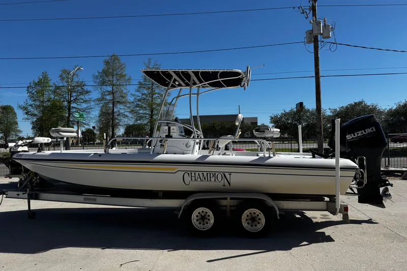 Slide: The Image of 2006 Champion 24 Bay Champ boat on trailer with Suzuki outboard motor. - 3