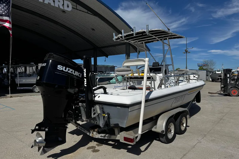 Slide: The Image of 2006 Champion 24 Bay Champ boat with Suzuki engine on trailer at a marina. - 8
