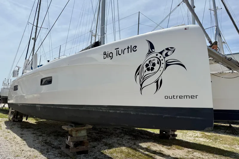 Slide: The Image of 2016 Outremer 45 catamaran "Big Turtle" with turtle graphic, docked on land. - 101