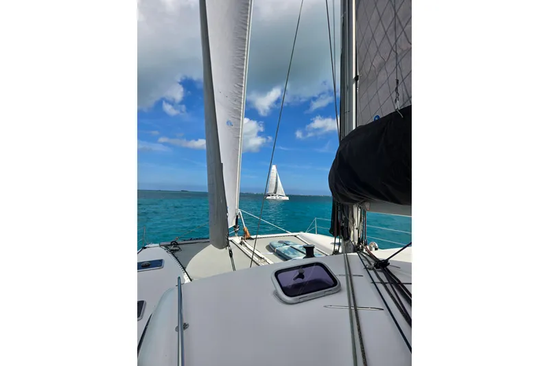 Slide: The Image of Sail of a 2016 Outremer 45 catamaran against a clear blue sky. - 108