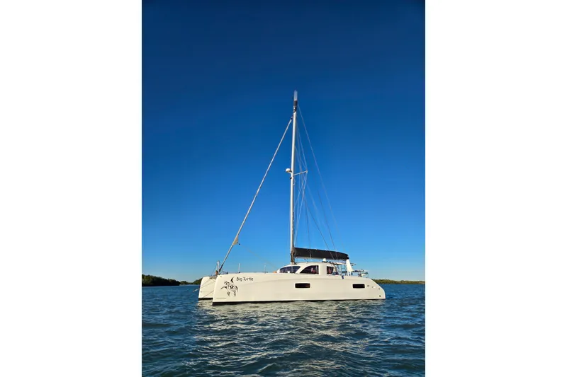 Slide: The Image of Sailing catamaran Outremer 45, 2016 model, gliding on turquoise ocean under cloudy skies. - 113