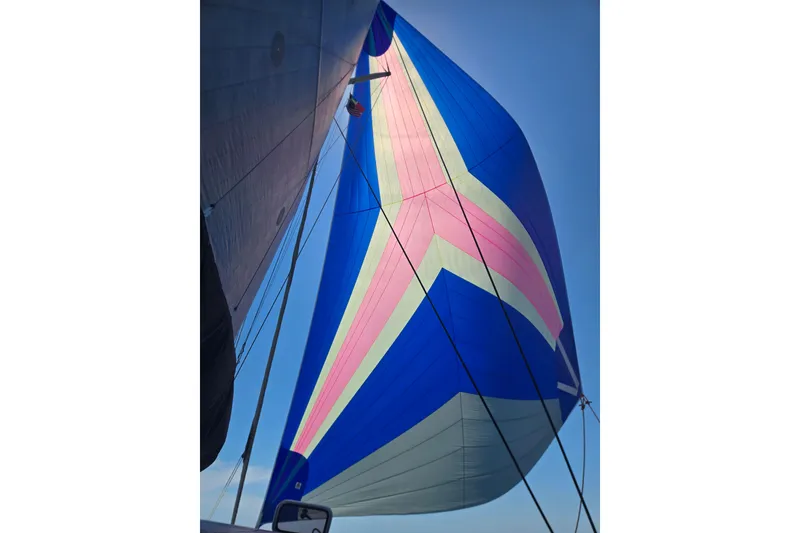 Slide: The Image of Colorful sail of a 2016 Outremer 45 catamaran against a clear blue sky. - 20