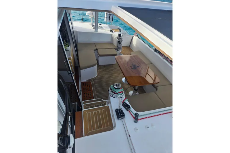 Slide: The Image of Outremer 45 catamaran 2016 model, featuring a spacious outdoor seating area with a wooden table. - 26