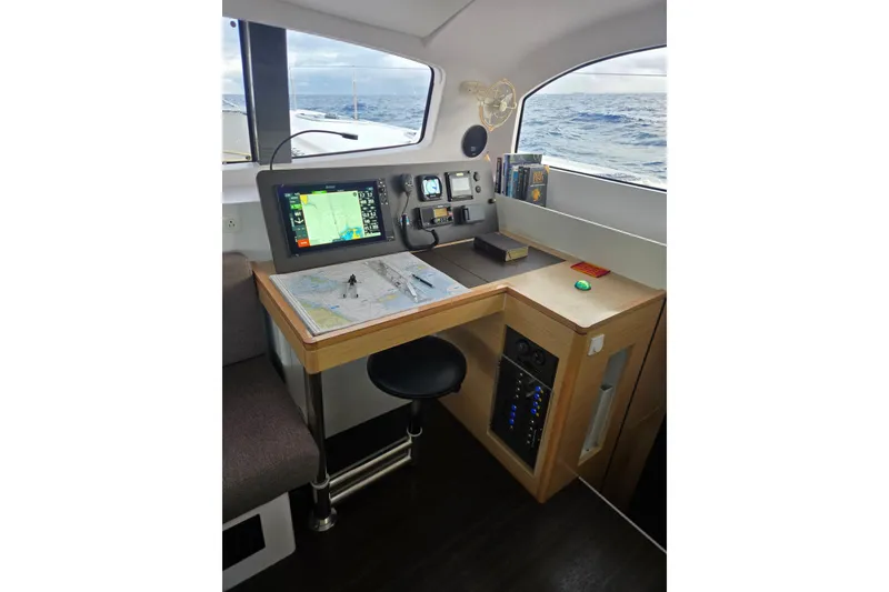 Slide: The Image of Navigation station inside 2016 Outremer 45 catamaran with map, instruments, and ocean view. - 33