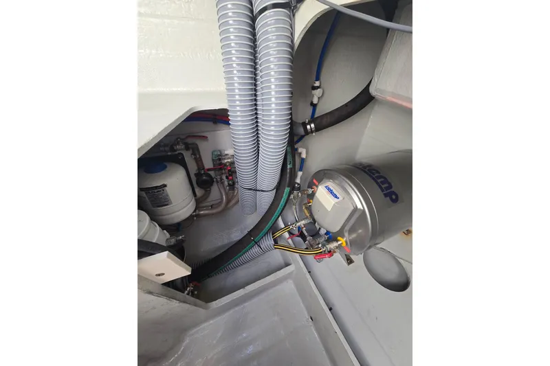 Slide: The Image of Engine compartment of a 2016 Outremer 45 yacht, featuring plumbing and mechanical components. - 49