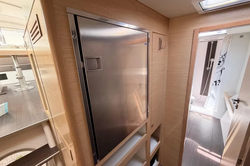 Slide: The Image of Interior of a 2016 Outremer 45 yacht, featuring a sleek stainless steel fridge and modern bathroom. - 61