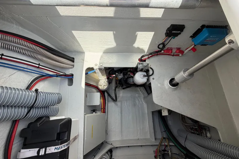 Slide: The Image of Engine compartment of a 2016 Outremer 45 catamaran, showcasing wiring and mechanical components. - 90