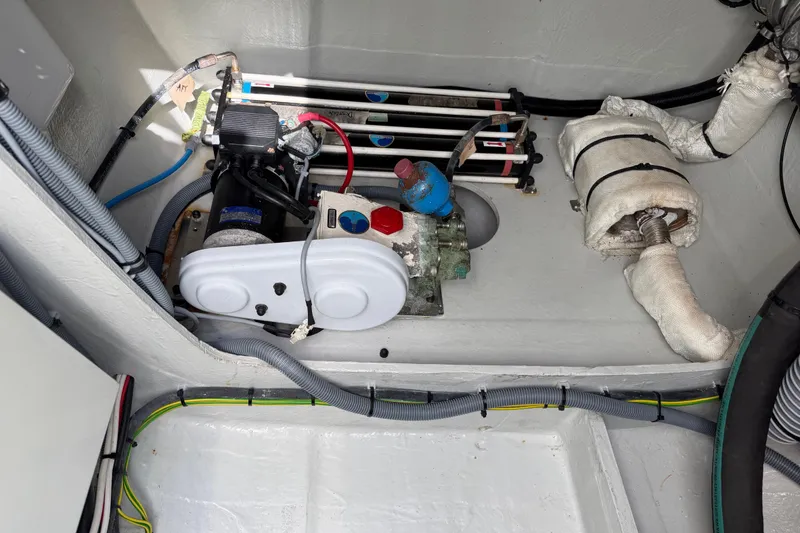 Slide: The Image of Engine compartment of a 2016 Outremer 45 catamaran, showcasing mechanical components and wiring. - 94