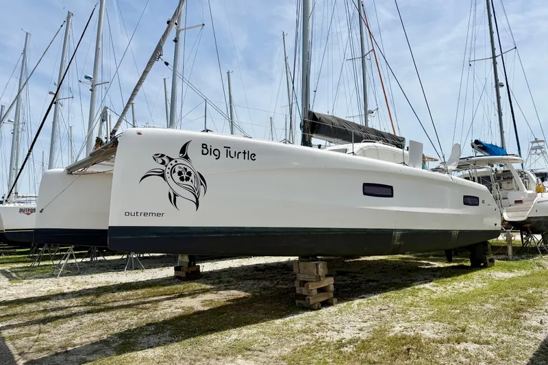 Slide: The Image of 2016 Outremer 45 catamaran "Big Turtle" on land, surrounded by other sailboats. - 99