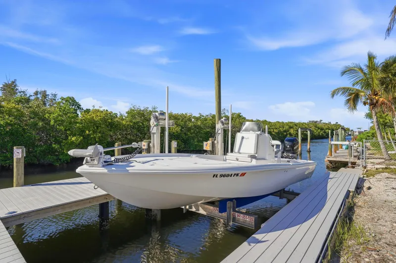 The Image of 2013 Yellowfin 24 Bay boat docked on a sunny day with lush greenery. - 0