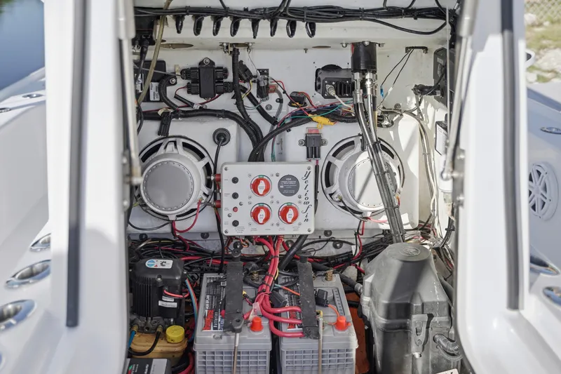 Slide: The Image of 2013 Yellowfin 24 Bay boat with console and seating, docked near lush greenery. - 2