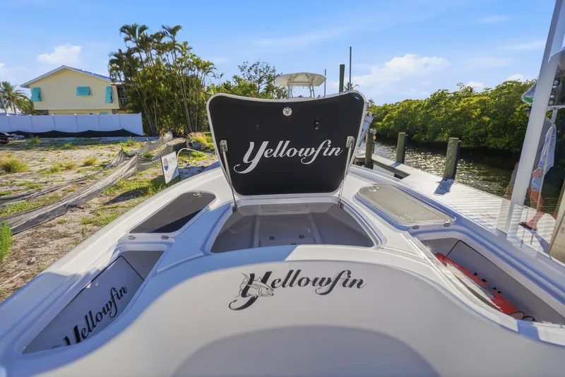 Slide: The Image of 2013 Yellowfin 24 Bay boat seat with logo, surrounded by lush greenery. - 20