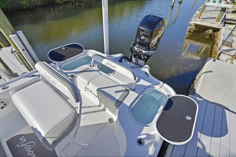 Slide: The Image of 2013 Yellowfin 24 Bay boat docked near lush greenery under a clear blue sky. - 24