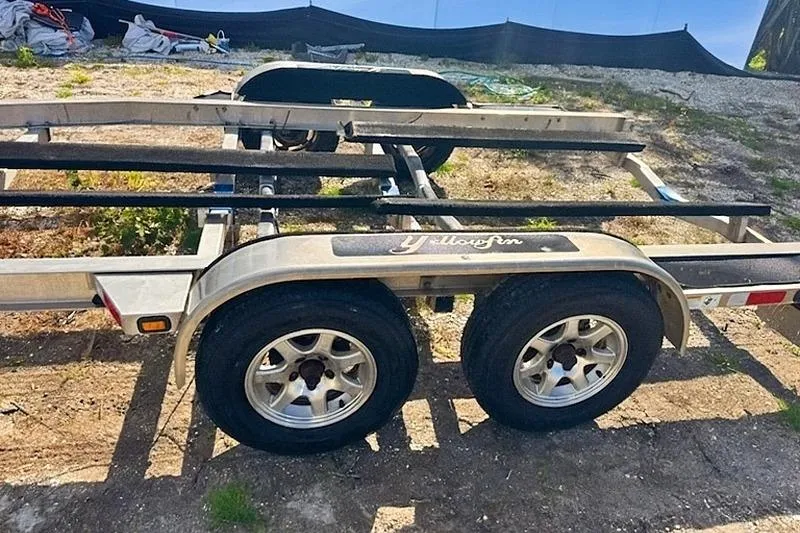 Slide: The Image of 2013 Yellowfin 24 Bay boat cruising near a scenic coastal shoreline. - 29