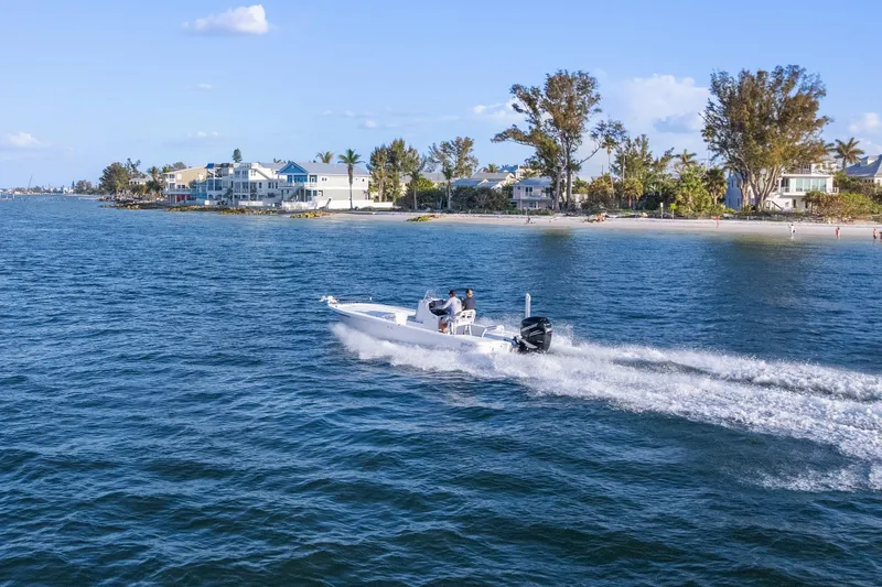 Slide: The Image of 2013 Yellowfin 24 Bay boat cruising on open water under clear skies. - 30