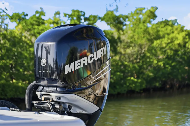 Slide: The Image of Mercury outboard motor on a 2013 Yellowfin 24 Bay boat, with lush greenery background. - 7