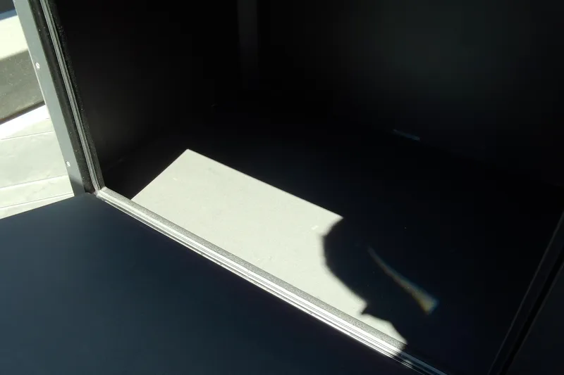 Slide: The Image of Interior storage compartment of 2026 Stabicraft 2050 Frontier boat, partially lit by sunlight. - 21