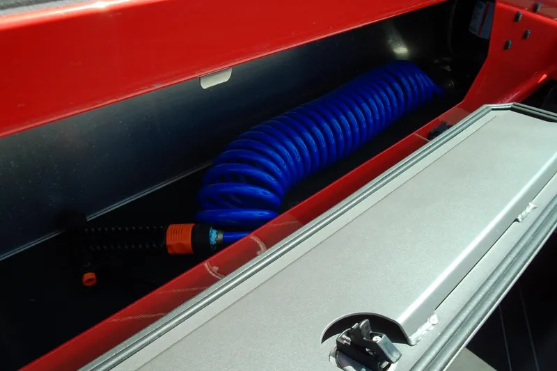 Slide: The Image of Storage compartment in 2026 Stabicraft 2050 Frontier with coiled blue hose. - 23