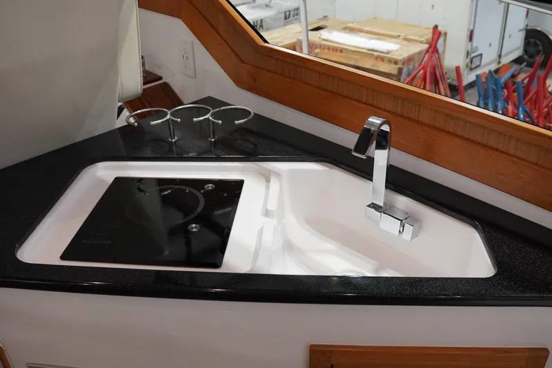 Slide: The Image of Modern kitchen sink and stovetop in 2024 True North 34 boat interior. - 11