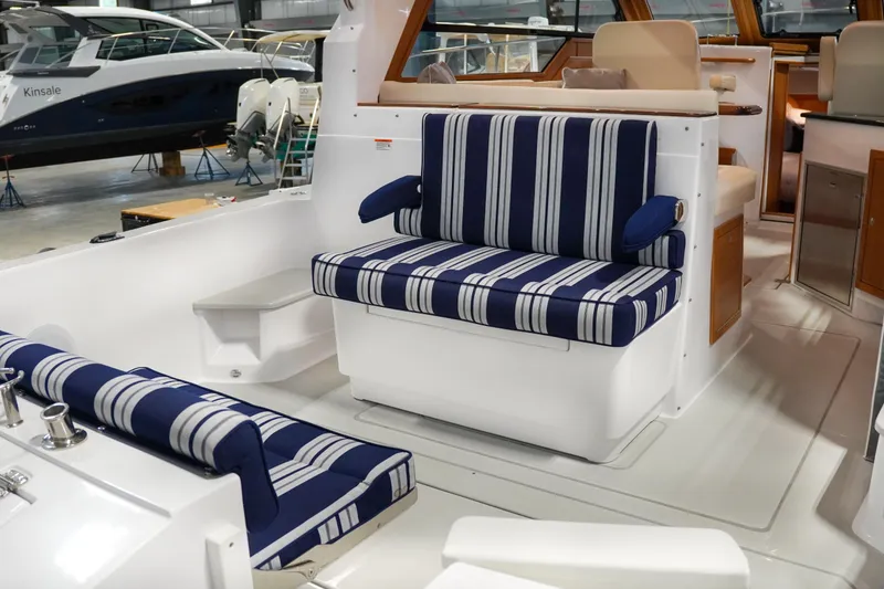 Slide: The Image of 2024 True North 34 boat interior with striped seating in a marina setting. - 23