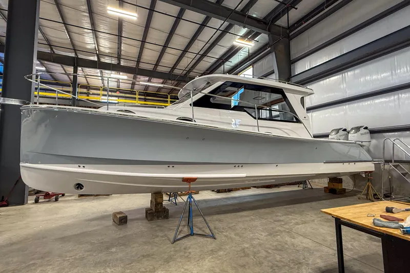 Slide: The Image of 2024 True North 34 boat in a warehouse, elevated on supports. - 34