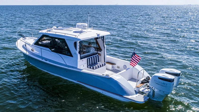 Slide: The Image of 2024 True North 34 Outboard Express boat on open water, American flag displayed. - 37
