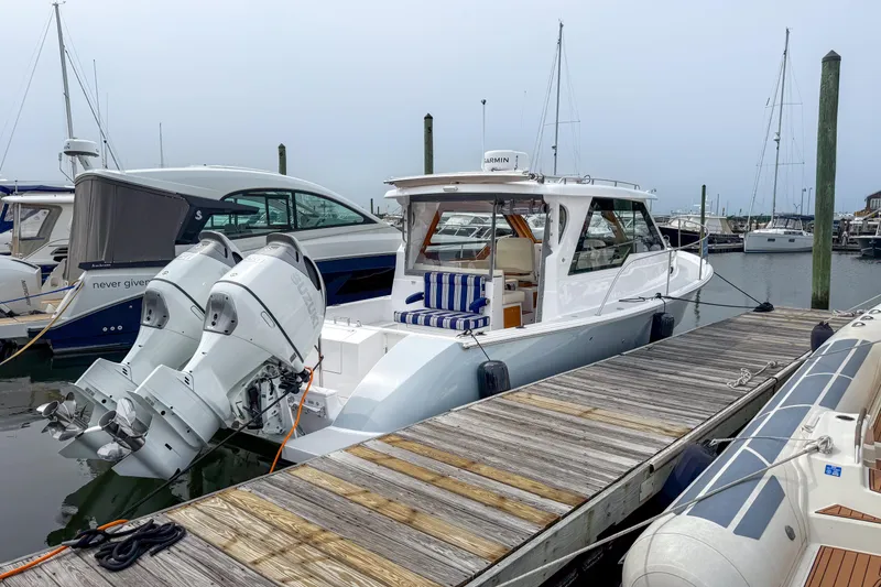 Slide: The Image of 2024 True North 34 boat docked with twin outboard engines at marina. - 40