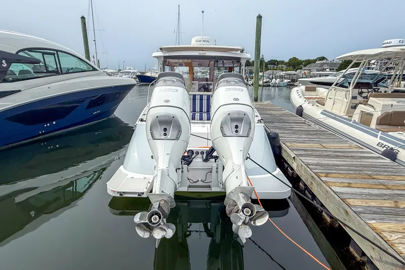 Slide: The Image of 2024 True North 34 boat docked with dual outboard engines in a marina. - 41