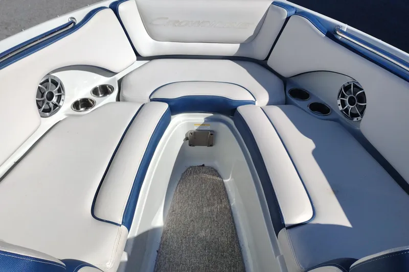Slide: The Image of 2017 Crownline 225 SS boat interior with blue and white seating, cup holders, and speakers. - 8