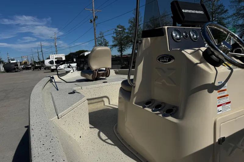 Slide: The Image of 2017 Xpress H20B Bay boat with steering console and seating, parked outdoors. - 15
