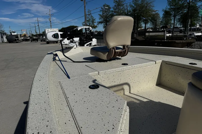 Slide: The Image of 2017 Xpress H20B Bay boat with beige seating and speckled deck, parked outdoors. - 17