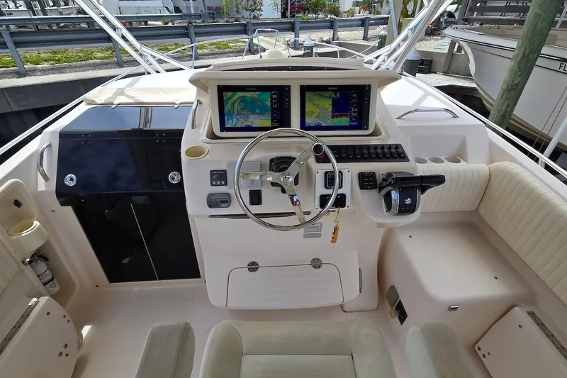 Slide: The Image of 2006 Grady-White Express 330 helm with dual navigation screens and steering wheel. - 12