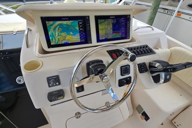 Slide: The Image of 2006 Grady-White Express 330 helm with dual Simrad displays and steering wheel. - 13