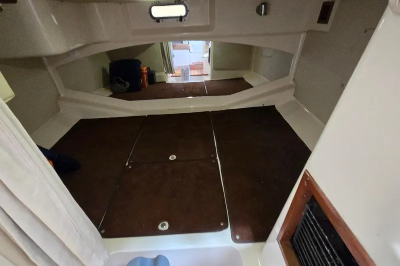 Slide: The Image of 2006 Grady-White Express 330 cabin interior with brown flooring and storage space. - 18