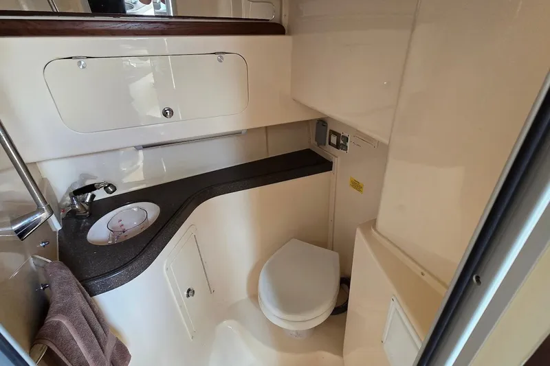 Slide: The Image of 2006 Grady-White Express 330 boat bathroom with sink, toilet, and storage cabinets. - 19
