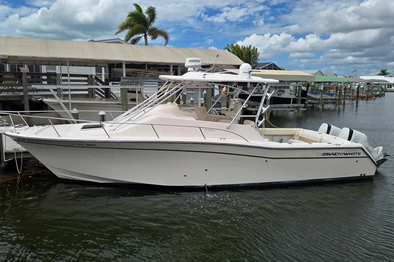 Slide: The Image of 2006 Grady-White Express 330 boat docked at marina under cloudy sky. - 2