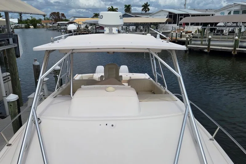Slide: The Image of 2006 Grady-White Express 330 boat docked at marina, featuring spacious deck and radar equipment. - 7