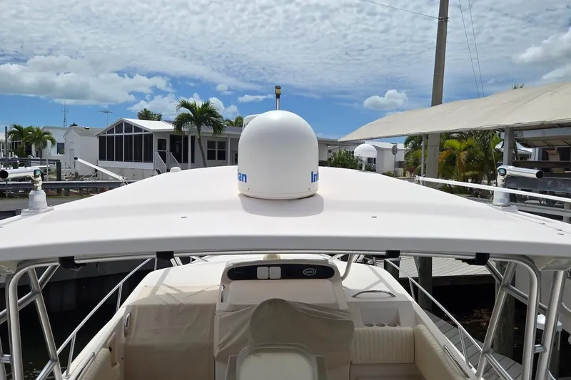 Slide: The Image of 2006 Grady-White Express 330 boat docked, featuring radar dome and spacious cockpit. - 8