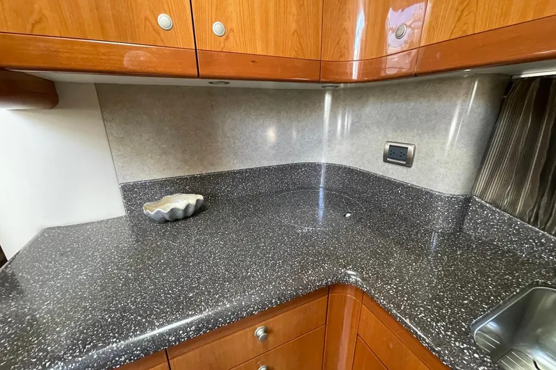 Slide: The Image of Luxurious kitchen countertop in a 2005 Formula 48 Yacht, featuring sleek wood cabinetry. - 13