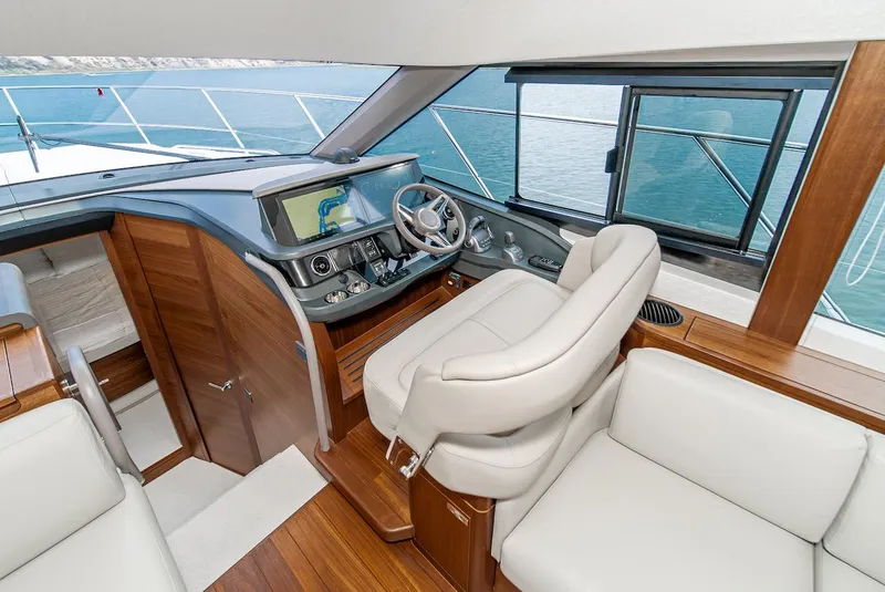 Slide: The Image of 2024 Princess F45 yacht helm station with modern navigation equipment and luxurious seating. - 34