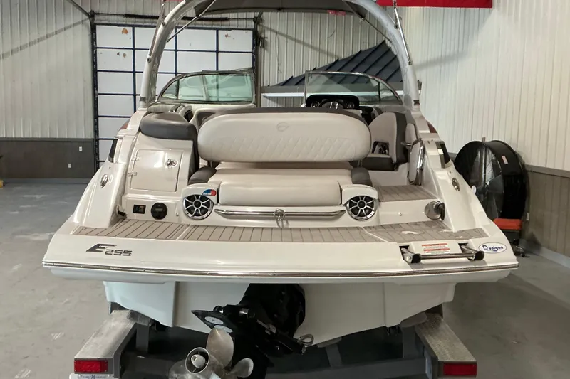 Slide: The Image of 2021 Crownline Eclipse E255 boat in a garage, rear view showing seating and speakers. - 24