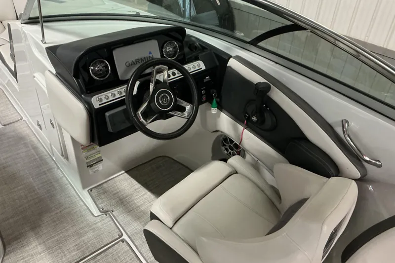 Slide: The Image of 2021 Crownline Eclipse E255 boat cockpit with steering wheel and Garmin display. - 25